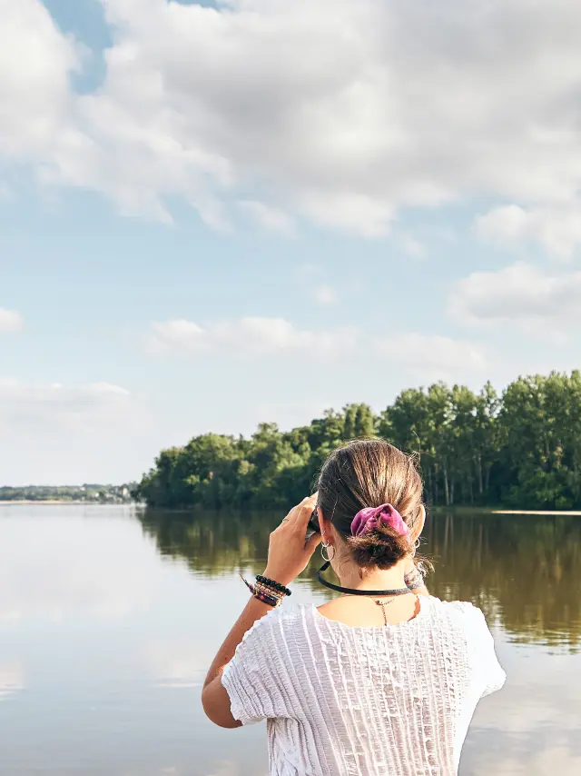 Deux jeunes femmes observant les oiseaux à la jumelles à l'avant d'un bateau sur la Loire