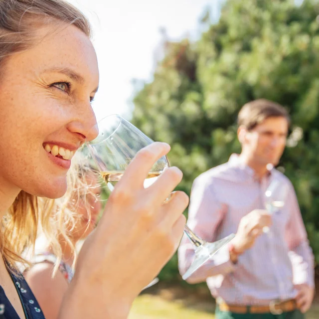 Femme portant un verre de vin blanc à son nez