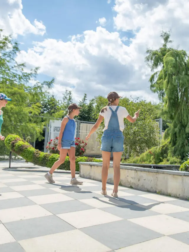 Une mère et ses deux filles regardant la sculpture végétale pieuvre