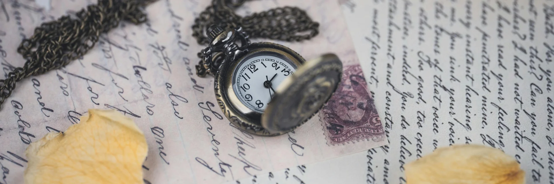 Lettres manuscrite avec une montre à gousset posée dessus