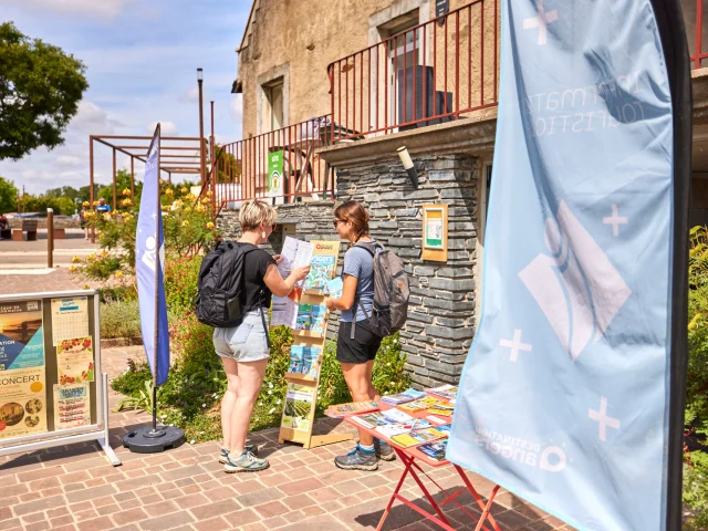 2 femmes consultant les brochures d'un présentoir à l'entrée du BIT