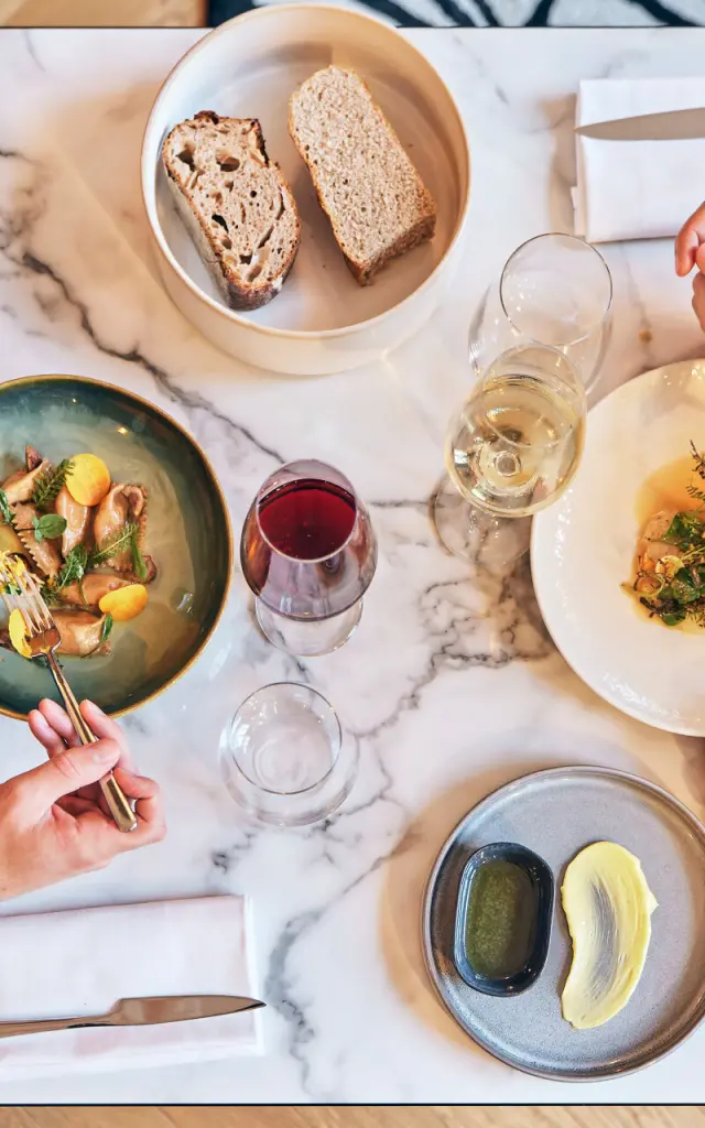 Plan en plongée sur une table de 2 personnes en train de manger