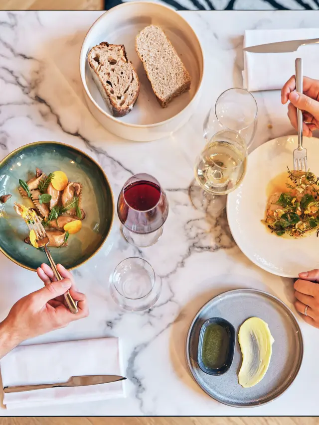 Plan en plongée sur une table de 2 personnes en train de manger