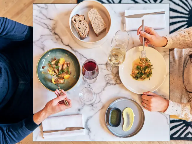 Plan en plongée sur une table de 2 personnes en train de manger