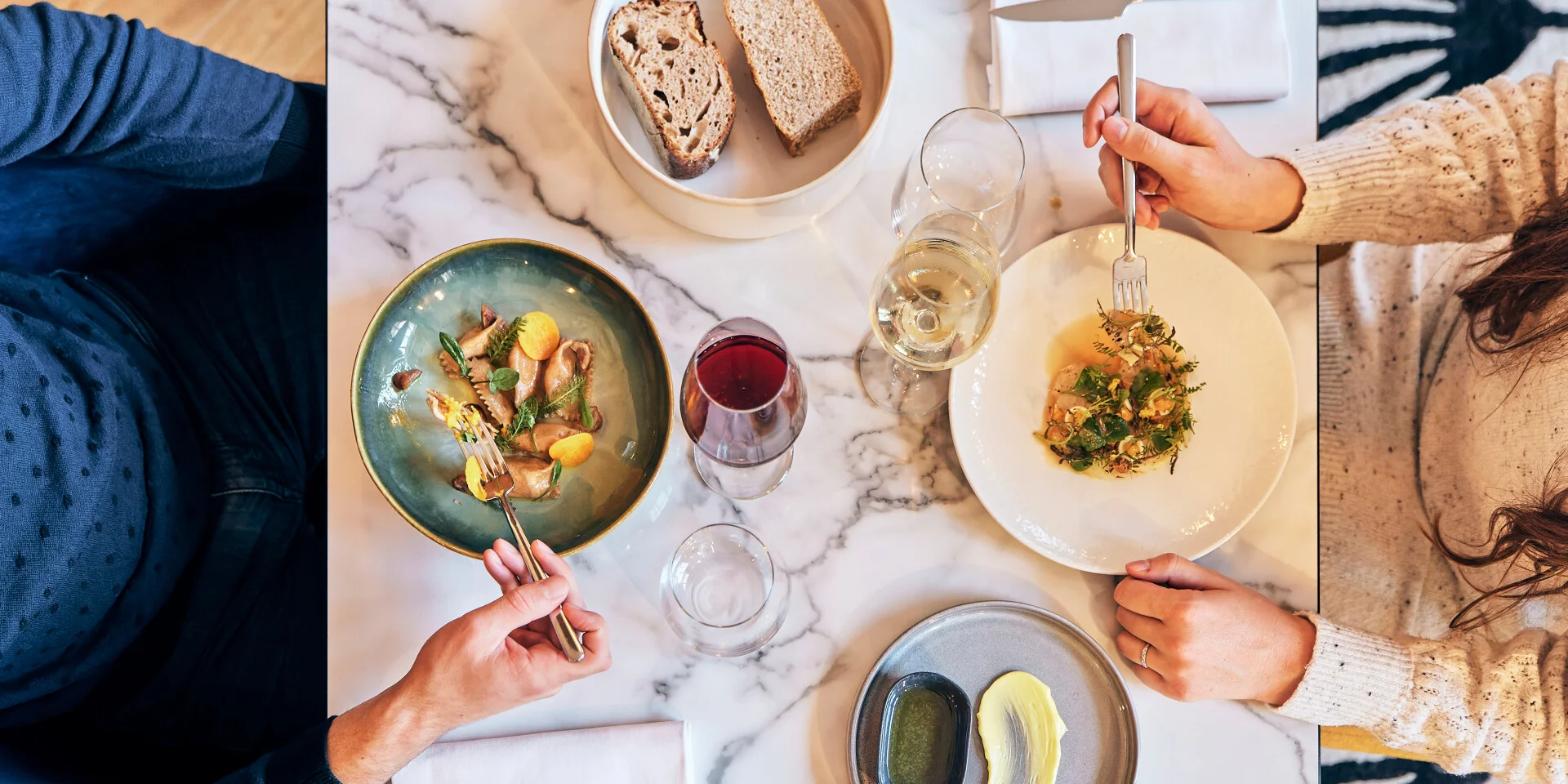 Plan en plongée sur une table de 2 personnes en train de manger