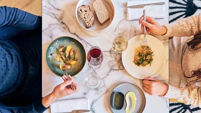 Plan en plongée sur une table de 2 personnes en train de manger