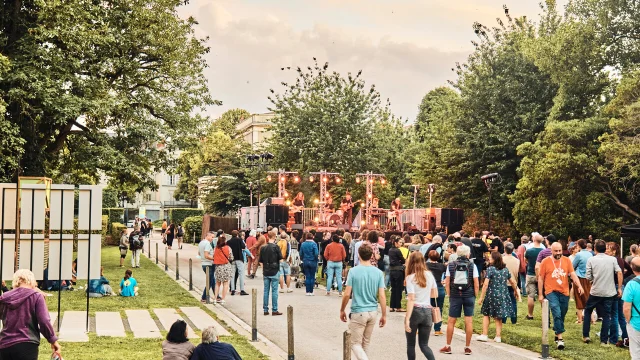 Plan large sur la foule de spectateurs réunis pour un concert sur les pelouses du jardin du musée