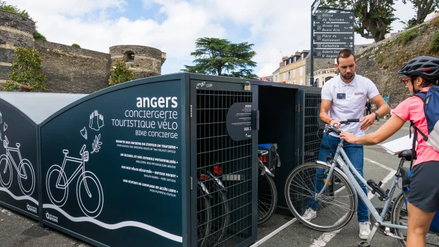 Cyclistes déposant leurs vélos dans un box de la conciergerie