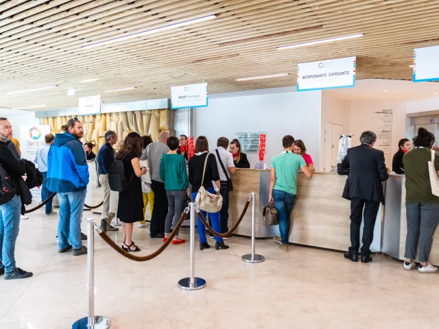 Personnes faisant la queue pour arriver à la borne d'accueil