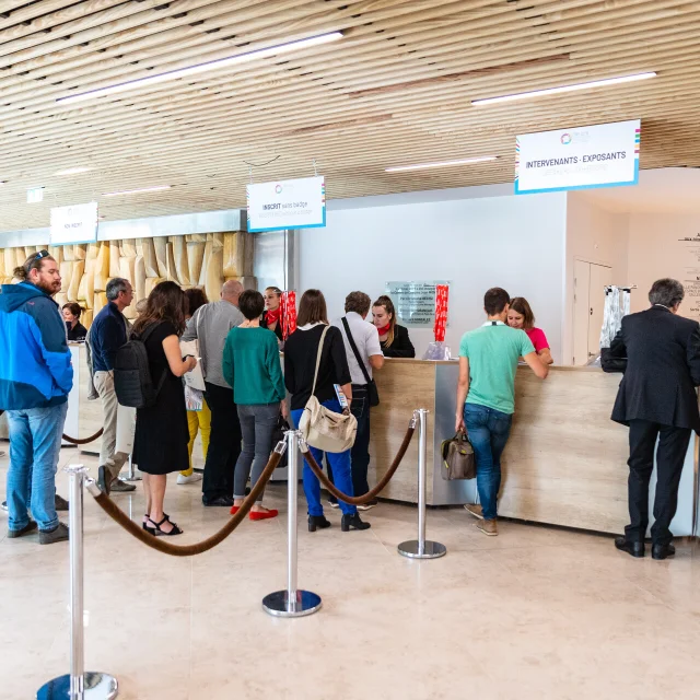 Personnes faisant la queue pour arriver à la borne d'accueil