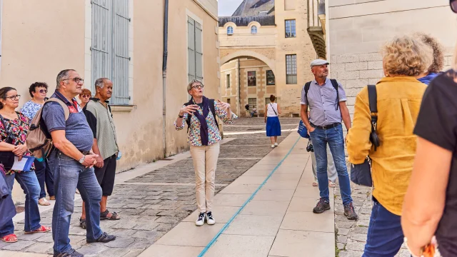 Groupe de seniors écoutant les explications de la guide conférencière dans une rue d'Angers
