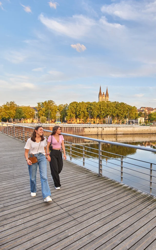 Deux jeunes femmes en tee-shirts, marchant sur le pont en fin de journée