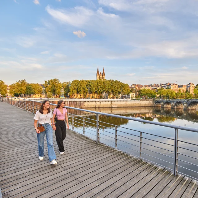 Deux jeunes femmes en tee-shirts, marchant sur le pont en fin de journée
