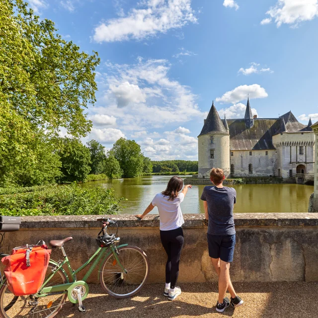 Des amis en balade à vélo, devant le château du Plessis-Bourré