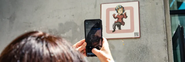 Femme scannant une plaque Cryptors au mur