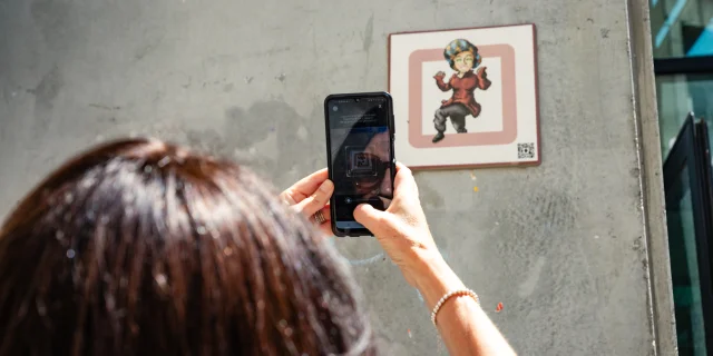 Femme scannant une plaque Cryptors au mur