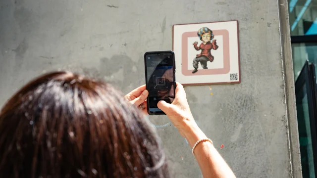 Femme scannant une plaque Cryptors au mur
