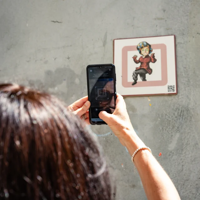 Femme scannant une plaque Cryptors au mur
