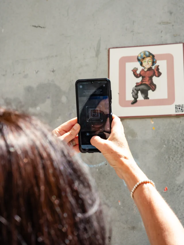 Femme scannant une plaque Cryptors au mur