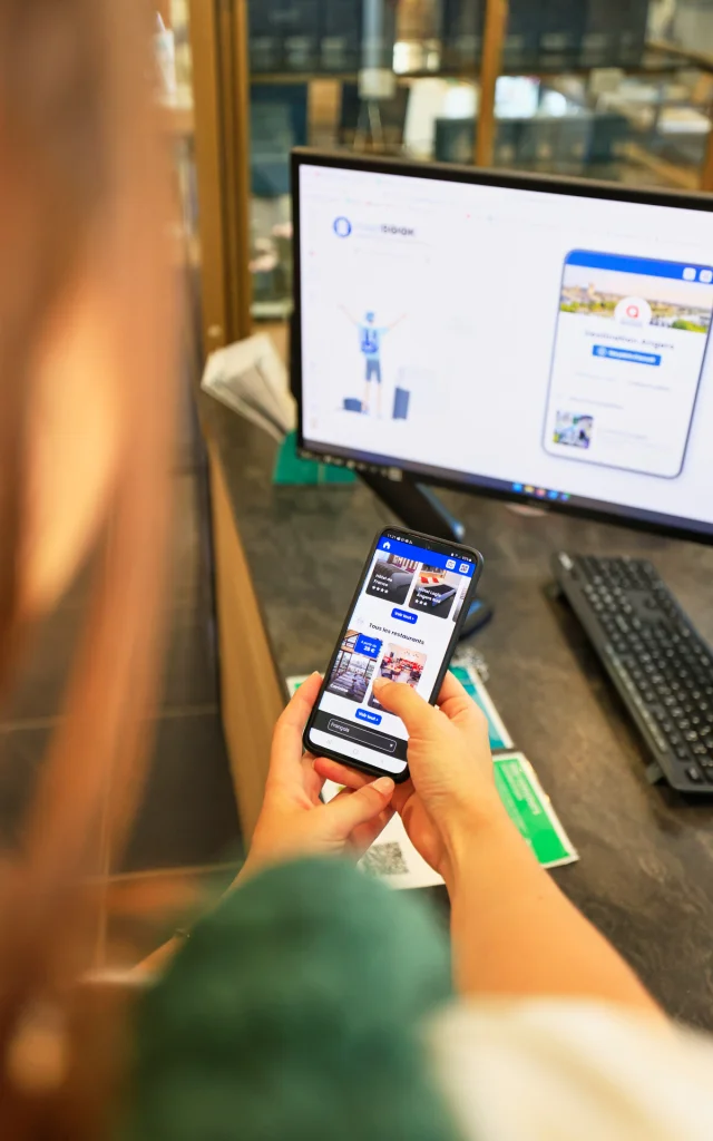 Carnet de séjour sur mobile dans les mains d'une femme