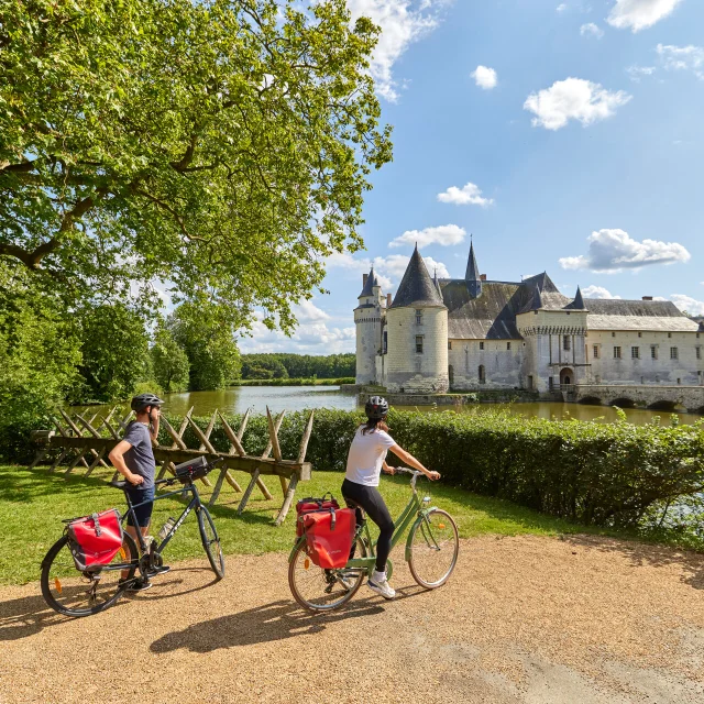 Plan large de deux cyclotouristes devant le Château du Plessis Bourré