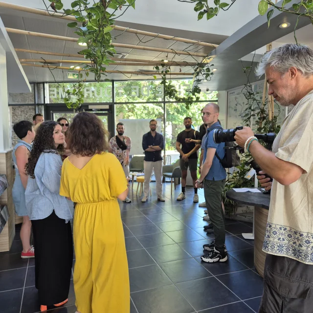Cameraman filmant un groupe reçu à l'accueil de l'Office de tourisme