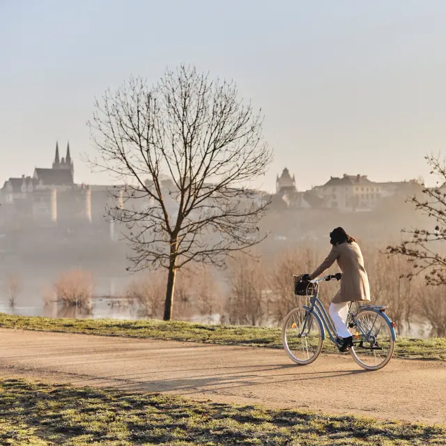Femme à vélo sur les bords de la Maine en hiver